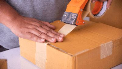 Close-up of staff sealing a box of bubble tea ingredient samples for shipment