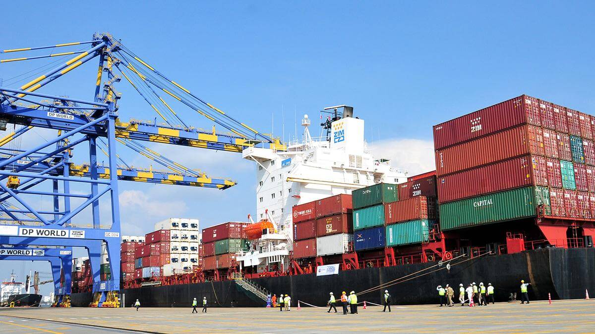 Container ship loading at an international port with cranes and workers, representing global trade and logistics operations