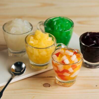 Colorful coconut boba and jelly toppings in assorted shapes and flavors including heart, star, mango, and grape.