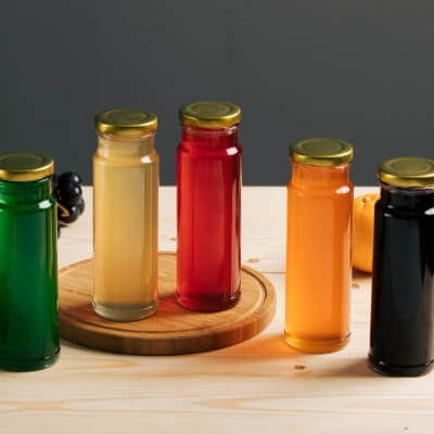 Assorted bubble tea syrup bottles in various fruit and tea flavors including mango, strawberry, lychee, and black tea